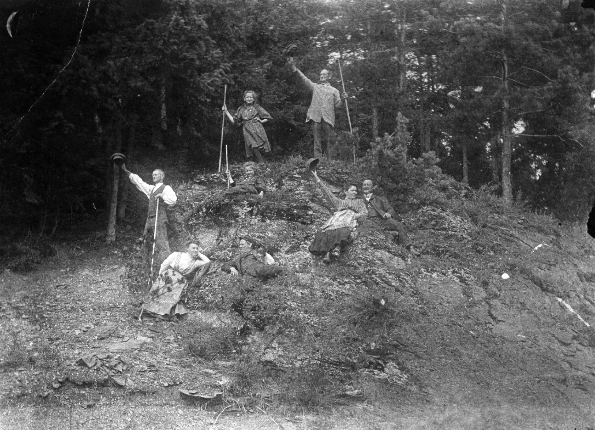 Historische Gruppe aus Abberode auf einer bewaldeten Anhöhe; mehrere Menschen halten lange Stangen oder heben ihre Hüte