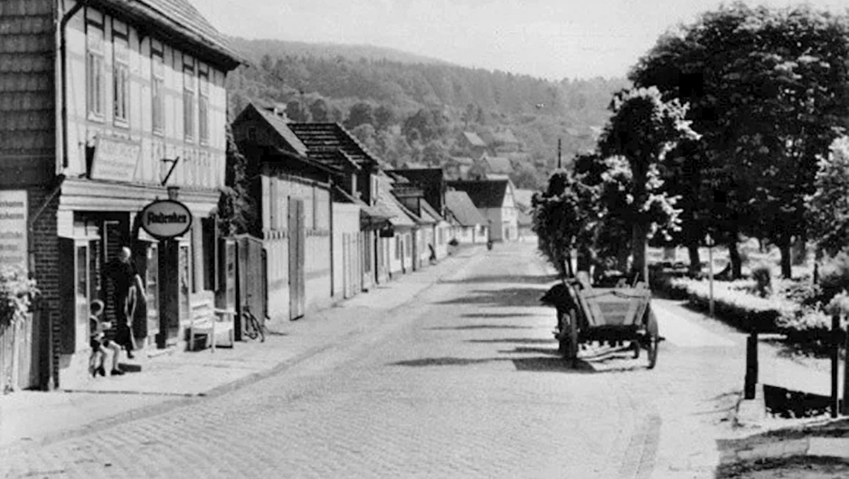 Historische Ansicht der Bahnhofstraße in Wippra mit Fachwerkhäusern und einem Pferdewagen.