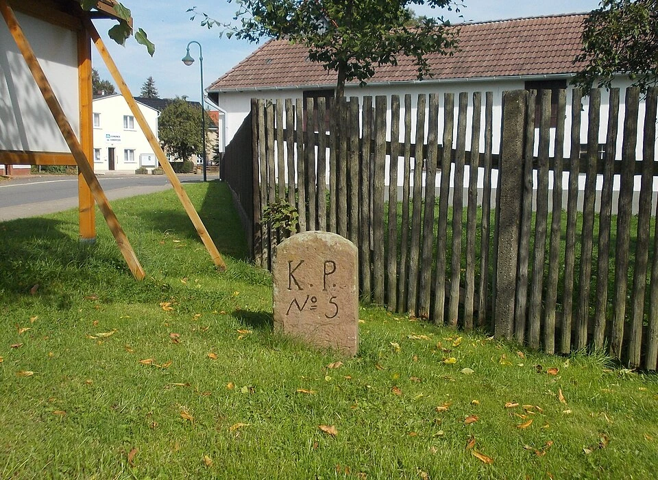 Zwischen Zaun und Dorfstraße steht noch ein Stück Landesgrenze: der Stein mit „K. P.“ und der Nummer 5.