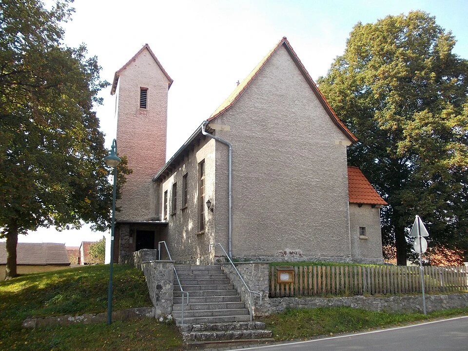 Die Treppe hinauf nach St. Wilhelm: Tilkerodes Kirche zwischen Bäumen und Dorfstraße, September 2014.