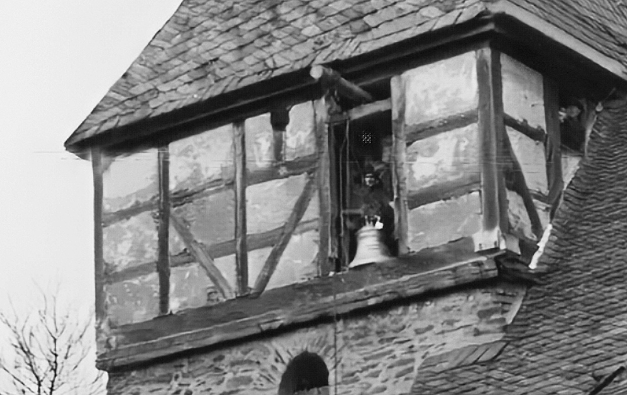 Nahansicht des geöffneten Fachwerkgeschosses mit Glocke, Seilen und beteiligten Männern