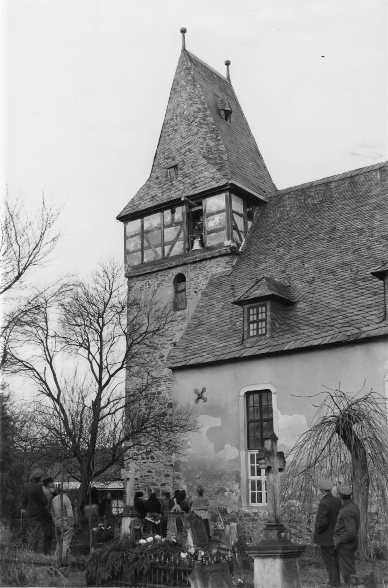 Kirche und Kirchhof 1931; vor dem geöffneten Glockengeschoss hängt eine Glocke