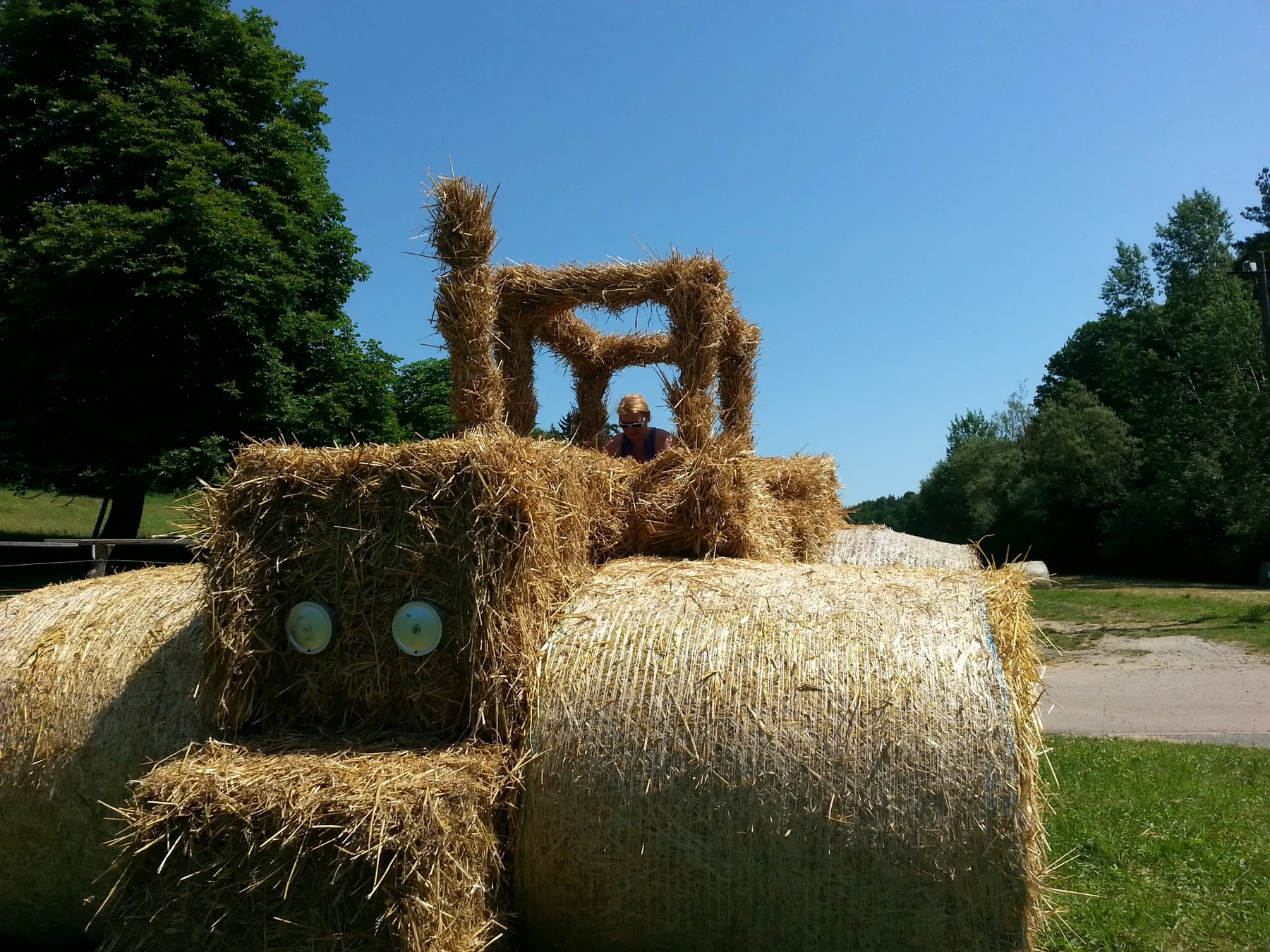 Aus Strohballen gebauter Traktor auf der Wiese bei der Untermühle, mit Besucherin